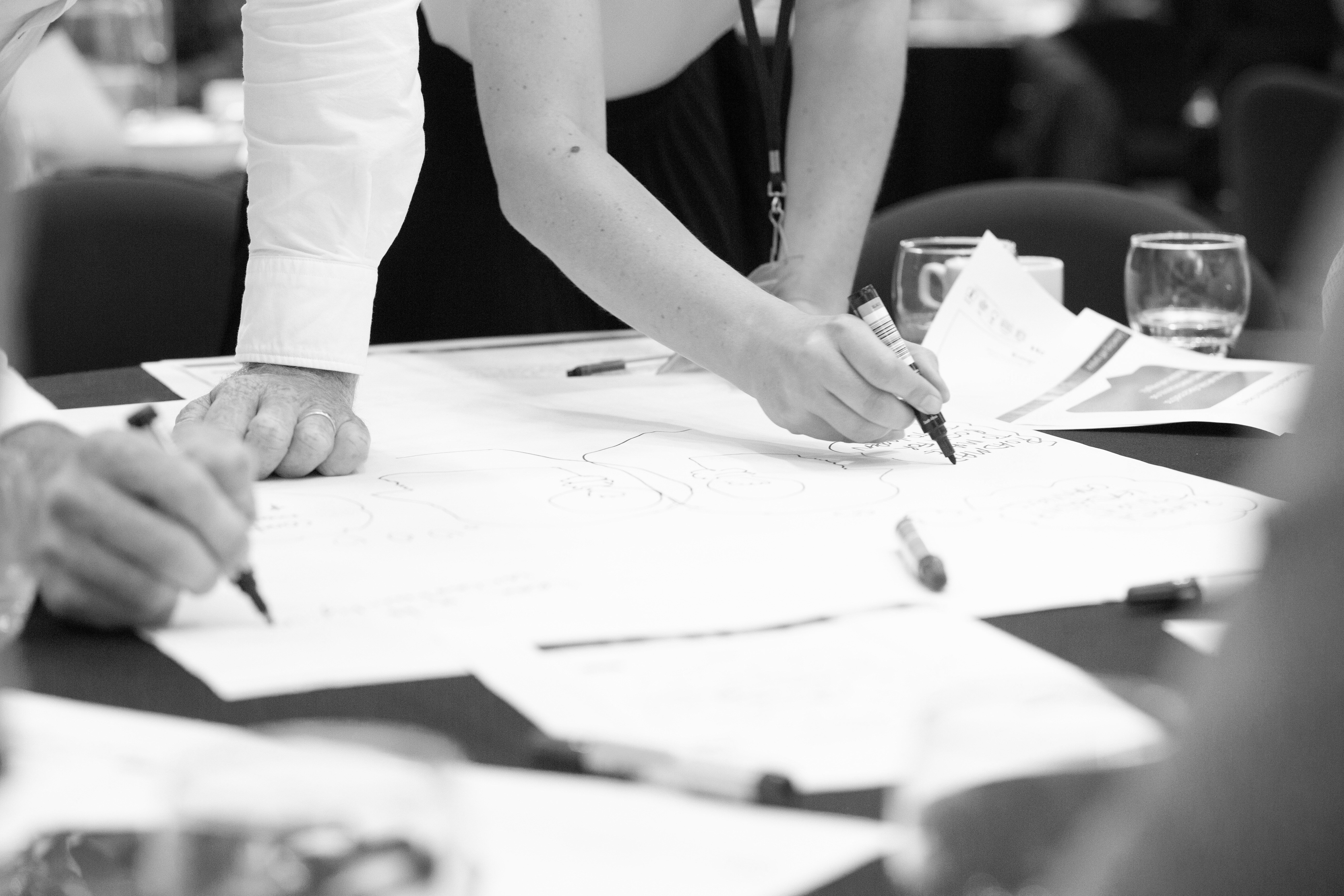 people working together over an A1 piece of paper
