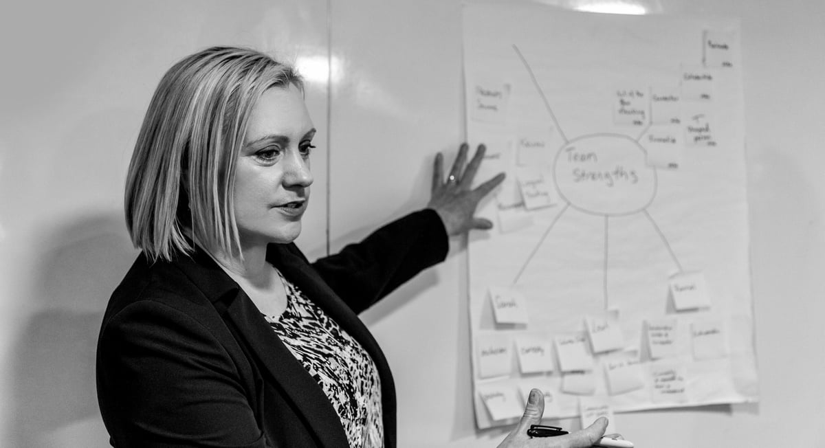 Jenny pointing at a white paper with sticky notes on