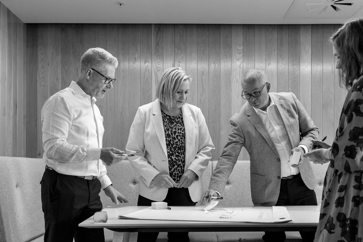 Four people standing around a table in a workshop setting